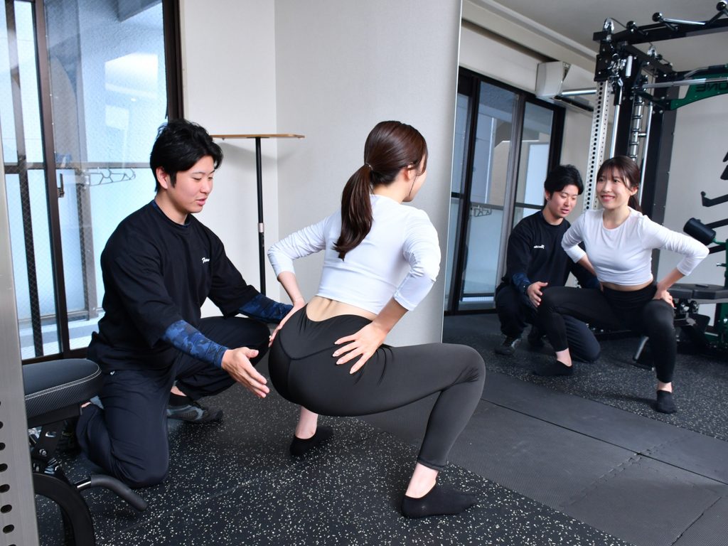 都島・京橋エリアのパーソナルジムEvolveでフォーム指導を受ける様子